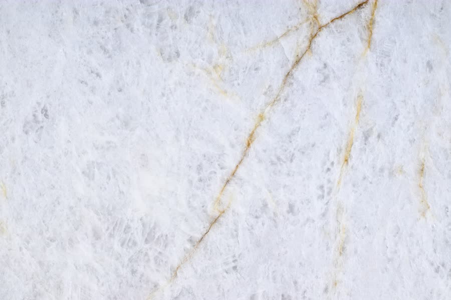 Crystallo Traslux — close view of the stone surface. Translucent white stone threaded with warm gold seams.