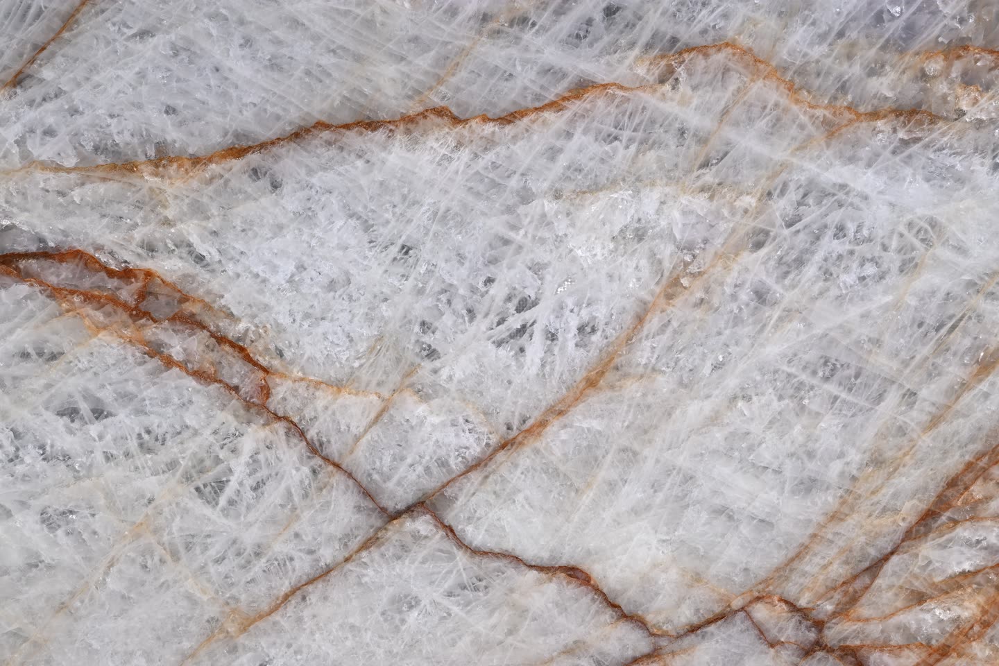 Rosso Crystallo — close view of the stone surface, translucent white crossed by rust-red and amber veining.