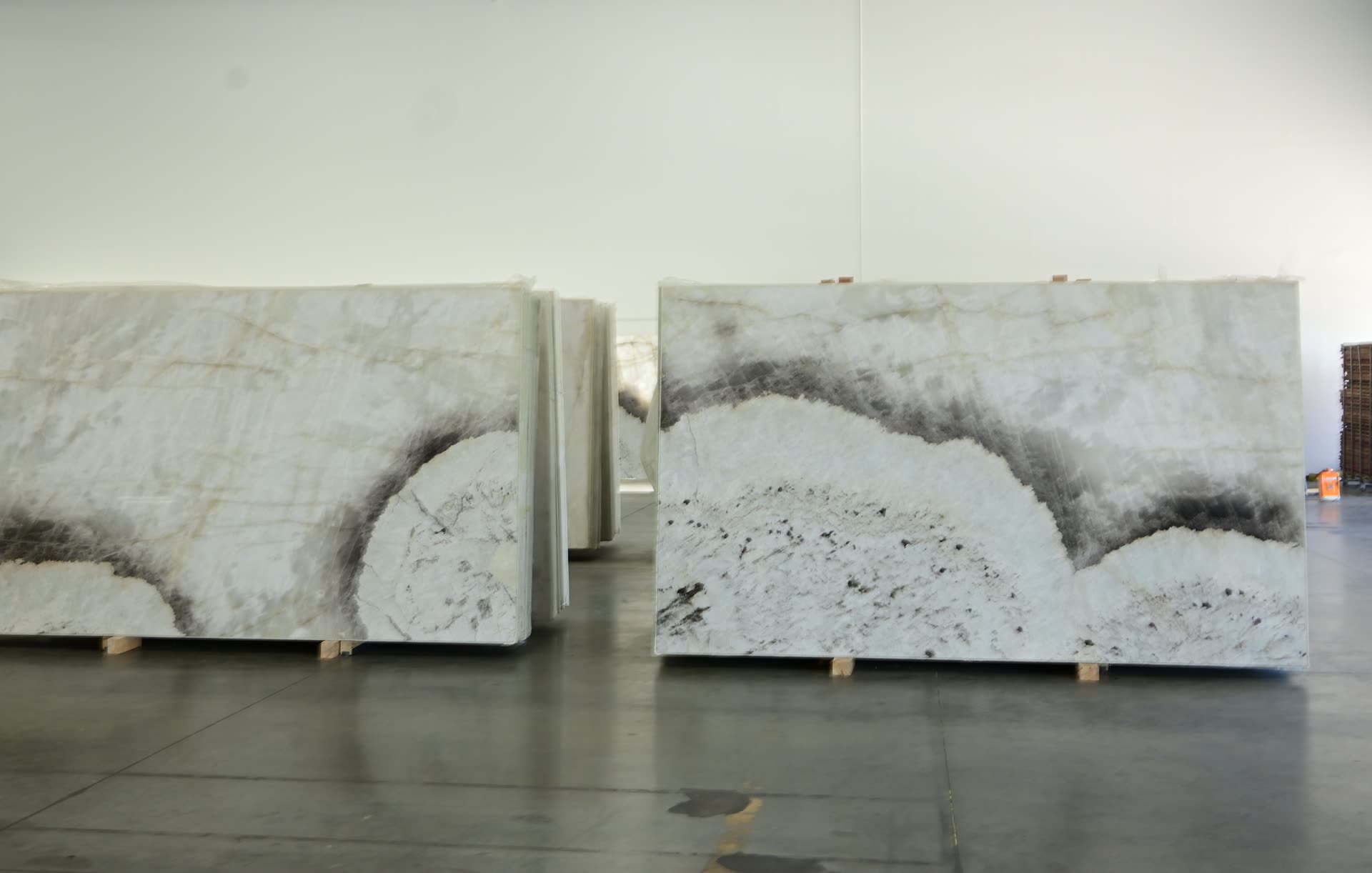 Two matching stone slabs standing side by side at the showroom, with further material stacked behind.