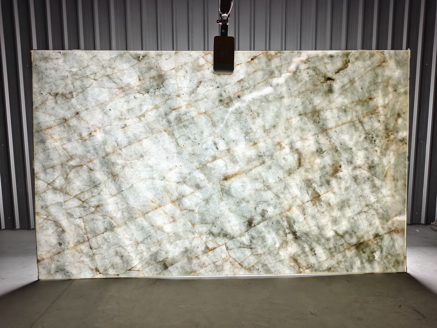 Verde Crystallo — the slab lit from behind so the translucency and vein structure read through the stone.