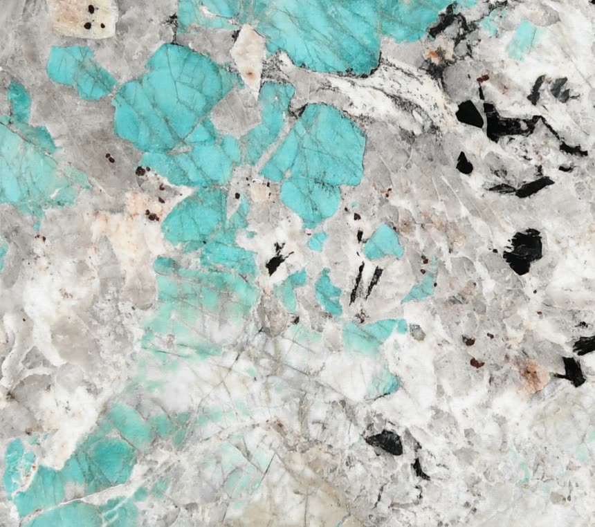 Amazonite — close view of the stone surface. Turquoise fields set into white and black mineral.