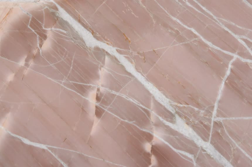 Splendido Brown — close view of the stone surface. Rose-pink ground with pale veining.