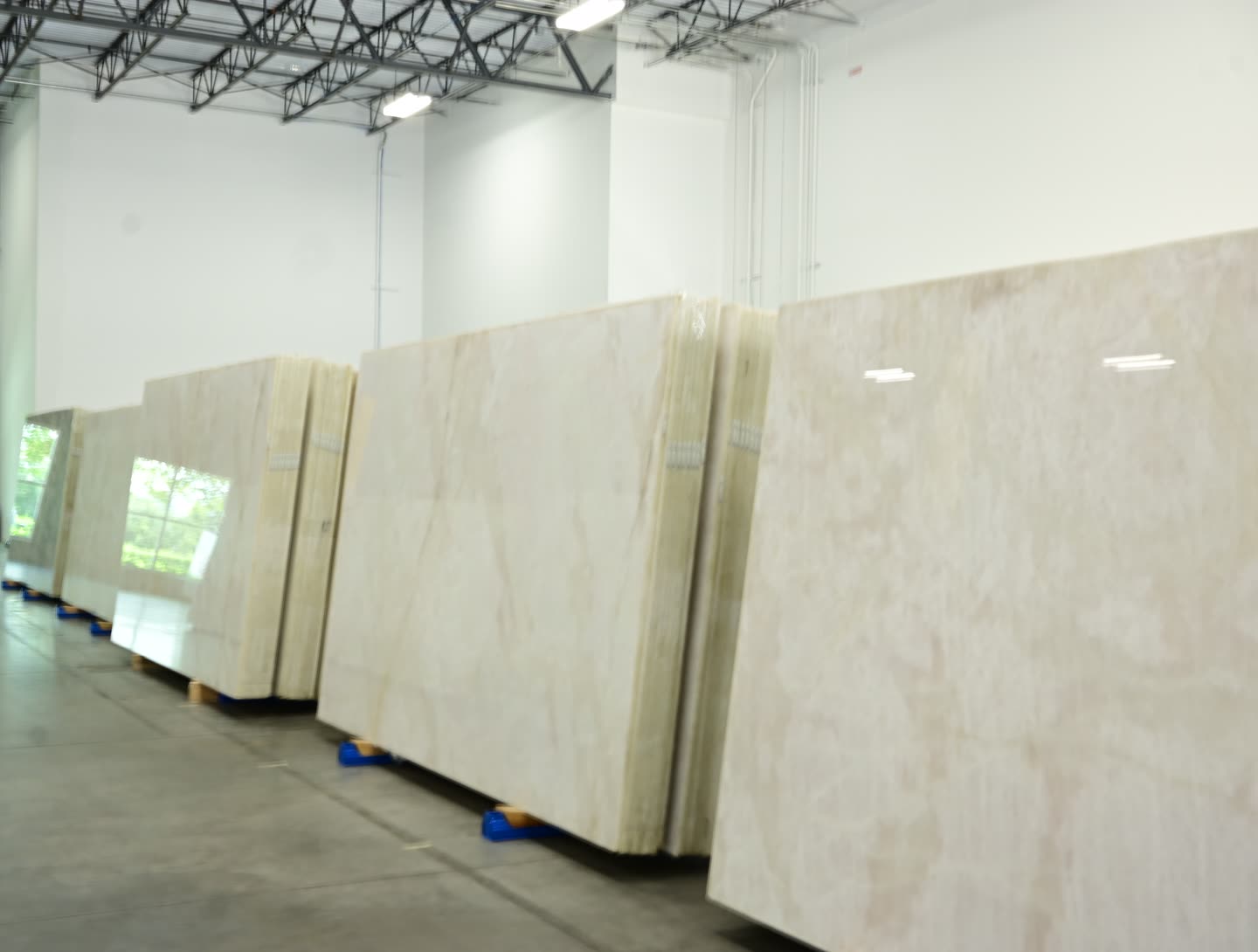 Stone slabs with grey and cream veining standing in a row at the showroom.